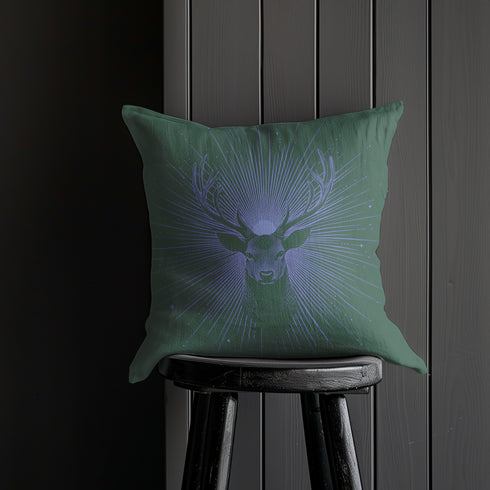 A pillow cover featuring a serene stag's face detailed in soft lavender, surrounded by radiating light beams on forest green fabric. Tiny stars twinkle throughout the design.